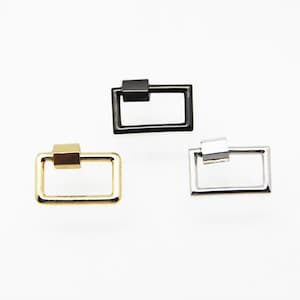 Puede incluir: Tres cierres de anillo en D de metal en negro, dorado y plateado.
