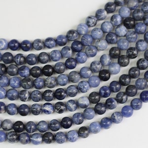 May include: A strand of blue and white gemstone beads. The beads are round and have a smooth, polished finish.