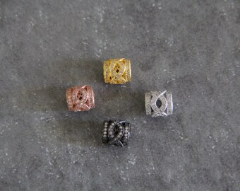 May include: Four small, round, decorative beads with a geometric design. The beads are made of metal and have a gold, silver, rose gold, and black finish. Each bead is adorned with small, clear rhinestones.