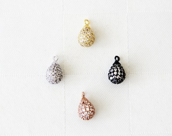 May include: Four teardrop-shaped pendants with a pave setting of clear rhinestones. The pendants are in gold, silver, black, and rose gold.
