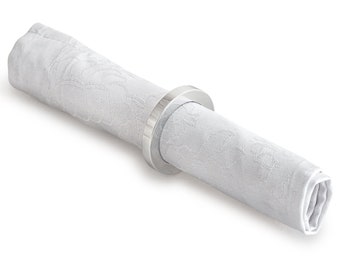 May include: A silver napkin ring holding a white linen napkin with a subtle embossed pattern.