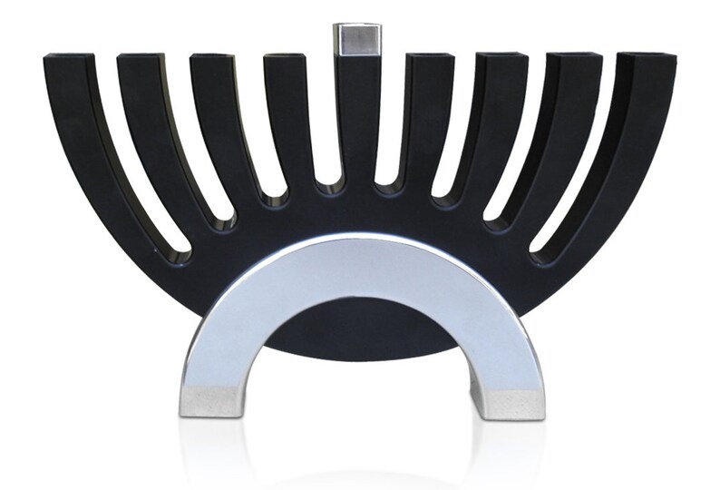 May include: A black menorah with a silver base. The menorah has nine candle holders, arranged in a semi-circle shape. The base is a silver arch.