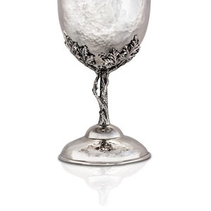 May include: A silver goblet with a hammered finish and a tree-like stem with leaves. The goblet has a wide base and a rounded bowl.