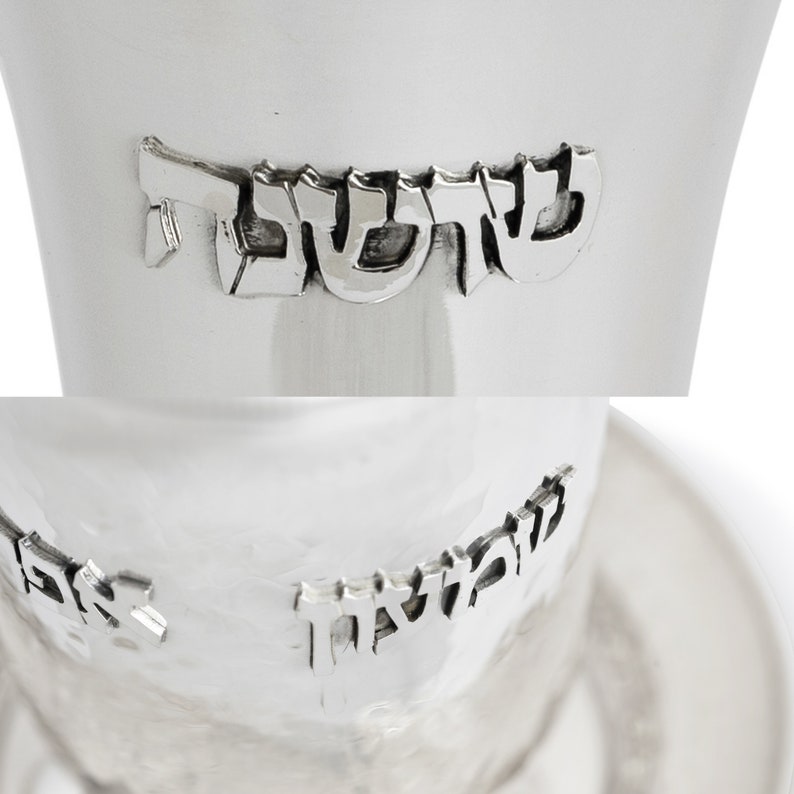 May include: A silver Kiddush cup with the Hebrew word "Kiddush" engraved on the side. The cup is sitting on a matching silver plate.