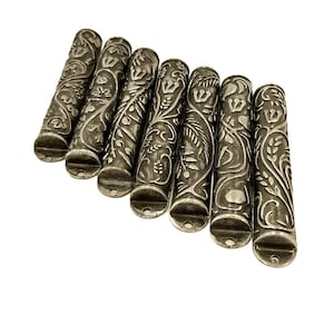 Puede incluir: Ocho tubos de metal plateados con un intrincado diseño floral. Cada tubo tiene un pequeño agujero en el extremo.