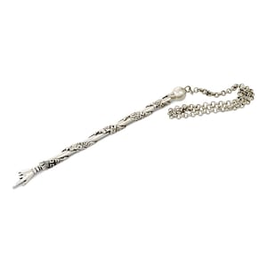 May include: A silver yad, a Jewish ritual pointer, with a decorative hand at one end and a pearl-like bead at the other end. The yad is attached to a silver chain.