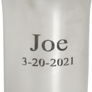 May include: A silver cup with the name "Joe" and the date "3-20-2021" engraved on it.