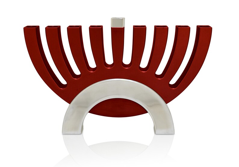 May include: A red menorah with a silver base. The menorah has nine candle holders and a shamash in the center.