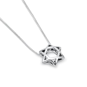 May include: A silver chain necklace with a silver Star of David pendant. The pendant is a double-layered, open design.