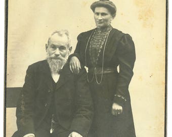 Cabinet card of a couple, the man holds a cigar