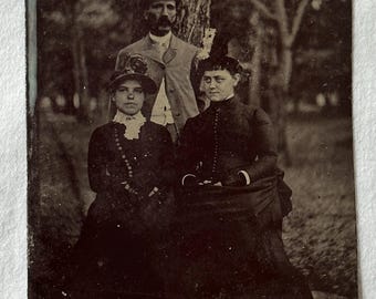 Tintype of three people posed outside in natural light