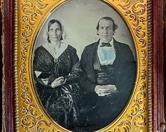 Quarter plate daguerreotype of a middle aged couple. The woman holds an open book. Full split case.