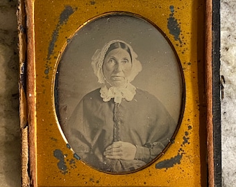 Early sixth-plate daguerreotype  of an older women in a bonnet. Half case.