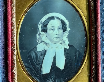 Ninth plate daguerreotype of a woman in a bonnet. Full case.