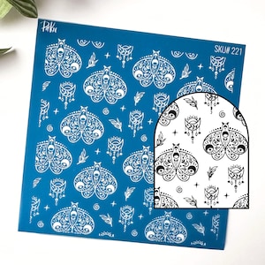 May include: A blue sheet featuring a repeating white pattern of moths, moons, stars, and leaves. The sheet has the text "Paku" in the upper left corner and "SKU# 221" in the upper right corner. A close-up of the pattern is shown.