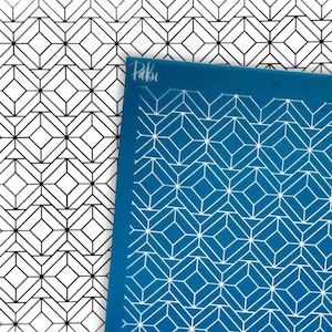 May include: A rectangular blue stencil sheet featuring a repeating geometric pattern of white lines forming interconnected diamonds and squares. The word Paku is printed in white in the top left corner of the stencil, which is layered over a black and white paper print of the same geometric design.