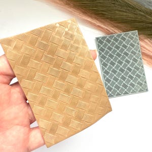 Może przedstawiać: Bliskie ujęcie beżowej silikonowej maty do tłoczenia z wzorem tkanym. Mata służy do tworzenia fakturowanych efektów na fondancie, glinie lub innych pracach ręcznych.