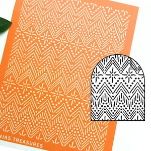 May include: An orange stencil featuring a white zigzag design with floral details. A smaller, black and white version of the design is in the corner. The text "NJAS TREASURES" is visible at the bottom.
