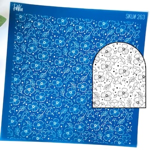 May include: A blue stencil with a floral design. The pattern includes white outlines of flowers, leaves, and dots. A smaller inset shows a close-up of the floral design. The stencil is labelled with "Paku" and "SKU# 263".