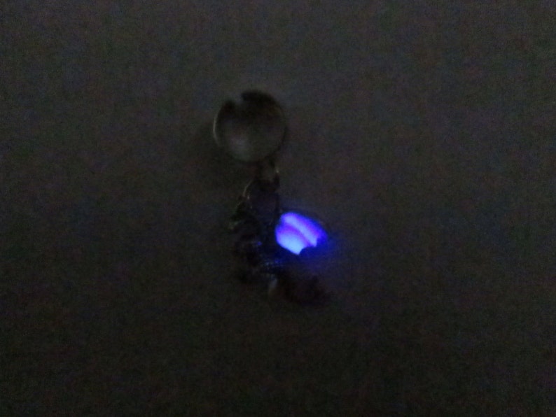 Tiny dragon ear cuff with purple glow in the dark wings