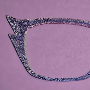 May include: A pair of iridescent glitter cat eye glasses with a silver frame.