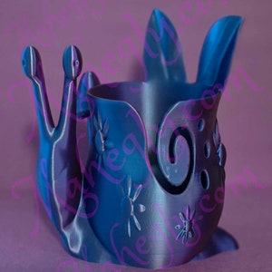 May include: A blue 3D printed snail-shaped pencil holder with a decorative swirl design and star-shaped cutouts.