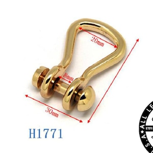 Puede incluir: Mosquetón giratorio de metal dorado con cierre de tornillo. El mosquetón mide 30 mm de largo, 20 mm de ancho y 8 mm de grosor. H1771.