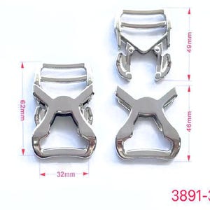 Può includere: Due fibbie in metallo argentato con una larghezza di 32 mm. La fibbia a sinistra è alta 62 mm e larga 46 mm. La fibbia a destra è alta 49 mm e larga 46 mm. Le fibbie sono etichettate 3891-32#.