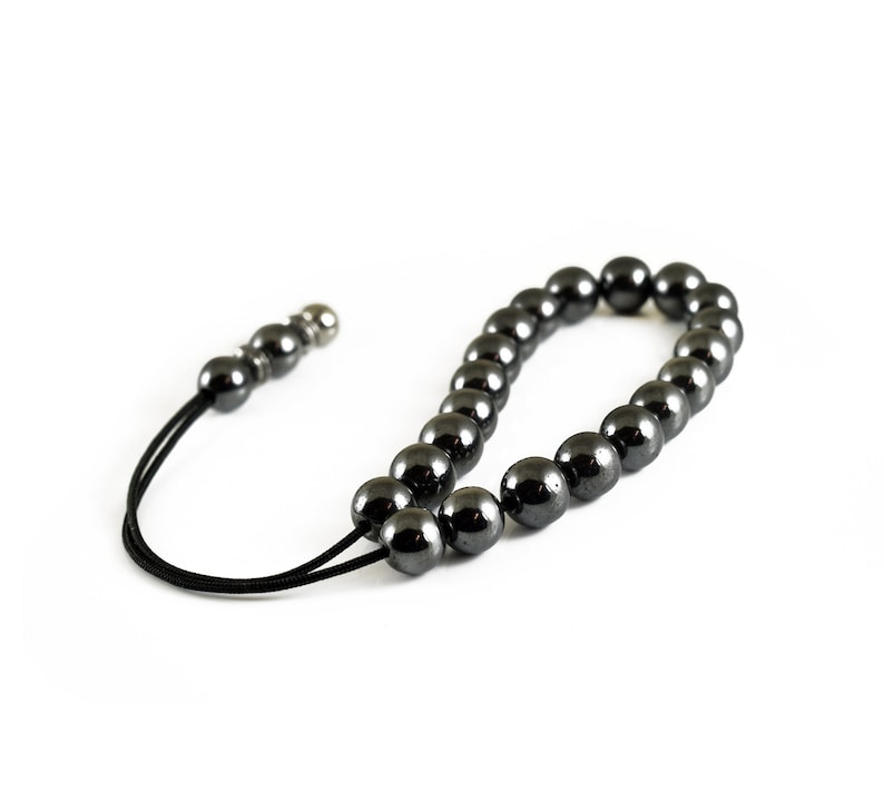 Puede incluir: Un collar de cuentas negras con un cierre plateado. Las cuentas son redondas y lisas, y el collar est&aacute; enhebrado en un cord&oacute;n negro.