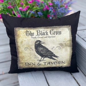 May include: Black throw pillow with a vintage-style graphic of a crow and the text "The Black Crow Family Owned and Operated Est. 1805 Inn & Tavern".