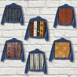 May include: Six denim jackets with different patterned fabric patches on the back. The patches feature geometric designs in shades of brown, yellow, white, and black.
