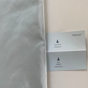 May include: Two paint color swatches, one labeled "Sea Frost PPG1037-1" and the other labeled "Sky Splash PPG1037-2". The swatches are on a white background. THD-E21 is printed in the top right corner.