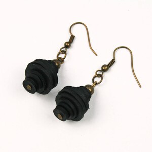 May include: A pair of black leather earrings with a spiral design and bronze hooks.