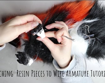 May include: A tutorial image showing the process of attaching resin pieces to a wire armature. The image features a furry fox tail with black, white, and orange fur. The text "ATTACHING RESIN PIECES TO WIRE ARMATURE TUTORIAL" is visible at the bottom of the image.