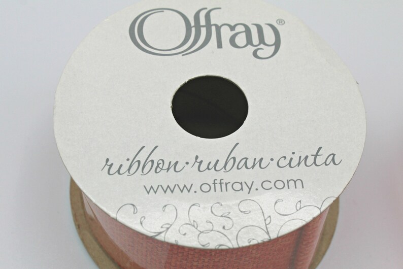 Pu&ograve; includere: Una bobina di nastro Offray in una tonalit&agrave; marrone rossastro. L'etichetta recita "ribbon ruban cinta" e "www.offray.com". Il nastro &egrave; ben avvolto, con un foro centrale. L'etichetta ha un design floreale.