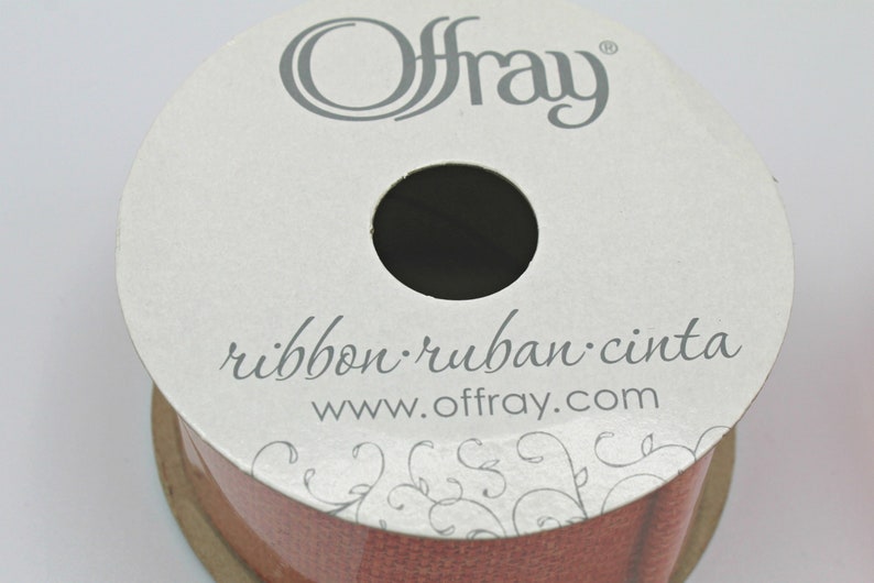 Pu&ograve; includere: Una bobina di nastro Offray in una tonalit&agrave; marrone rossastro. L'etichetta recita "ribbon ruban cinta" e "www.offray.com". Il nastro &egrave; avvolto strettamente, con un foro centrale. L'etichetta ha un design floreale.