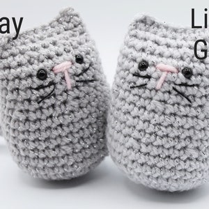 May include: Two crocheted cat toys, one gray and one light gray. Both have black eyes, pink noses, and black whiskers.
