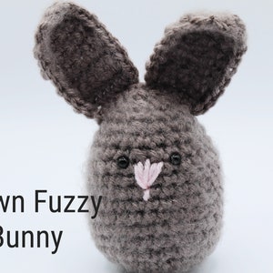 May include: A brown crocheted bunny with pink nose and black eyes.  Brown Fuzzy Bunny.
