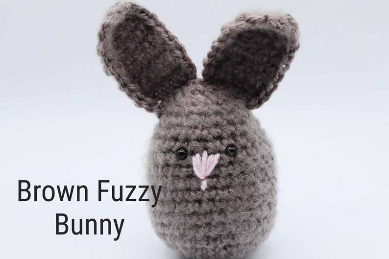 May include: A brown crocheted bunny with pink nose and black eyes.  Brown Fuzzy Bunny.