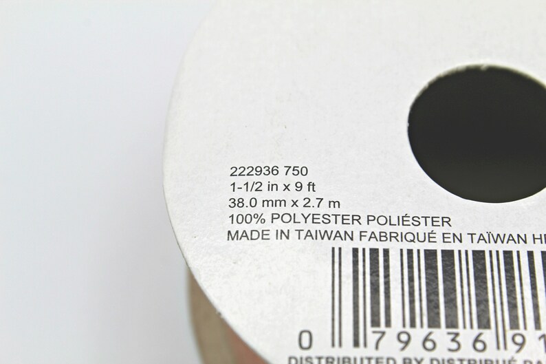 Pu&ograve; includere: Primo piano di un rotolo di nastro con testo stampato. Il testo include misure di 38,0 mm x 2,7 m e 1-1/2 pollici x 9 piedi. L'etichetta indica anche "100% POLYESTER POLI&Eacute;STER" e "MADE IN TAIWAN".