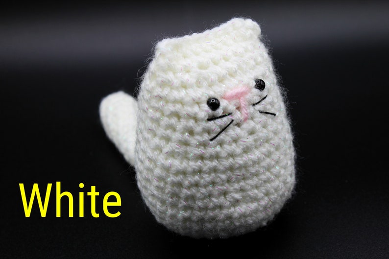 May include: White crocheted cat toy with black eyes and pink nose.