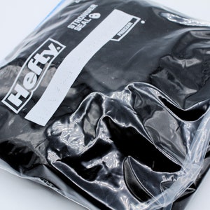 Pu&ograve; includere: Un sacchetto per congelatore nero del marchio Hefty con chiusura a zip. Il sacchetto &egrave; etichettato "Stronger Seal 8" e "Freezer".