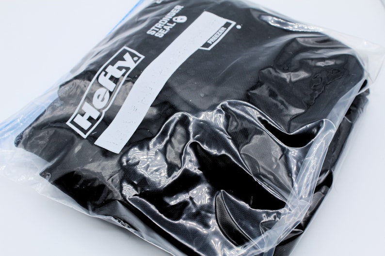 Pu&ograve; includere: Un sacchetto per congelatore nero del marchio Hefty con chiusura a zip. Il sacchetto &egrave; etichettato "Stronger Seal 8" e "Freezer".