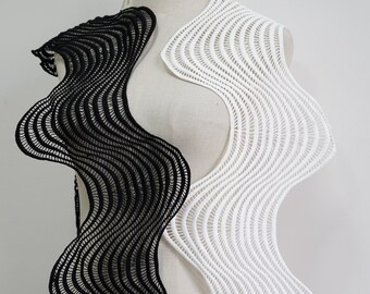 May include: Black and white crocheted fabric with a wavy design. The fabric is draped over a mannequin.