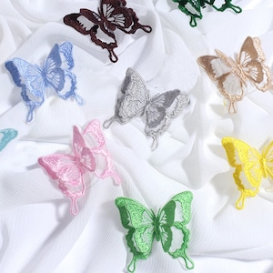 May include: Assortment of ten embroidered butterfly appliques in various colours, including green, blue, pink, yellow, brown, and grey. The butterflies are all the same size and shape, with delicate lace details.