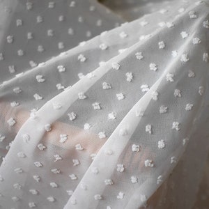 May include: White sheer fabric with a small white dot pattern.