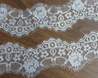 May include: White lace trim with a scalloped edge and floral pattern.