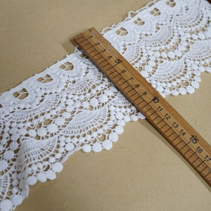 May include: White lace trim with a scalloped edge and a repeating pattern of small circles. The trim is measured with a ruler showing 18 inches.