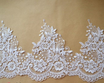 May include: White lace trim with a floral design. The lace has a scalloped edge and is perfect for adding a touch of elegance to any project.
