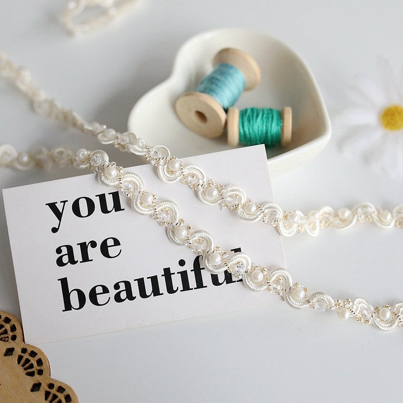 May include: White beaded trim with a scalloped edge and a message card that reads "you are beautiful".